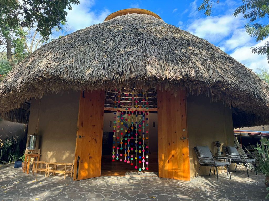 Entrada exterior de la maloca con cortina de colores en San Marcos La Laguna